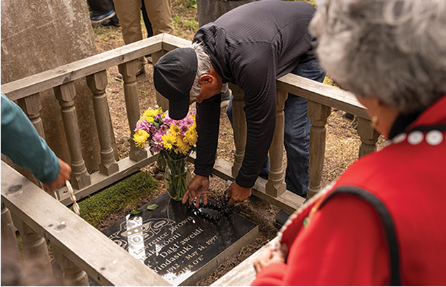 a person placing flowers on a grave