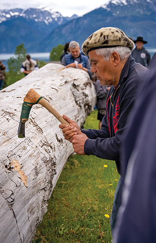 a person holding an ax over a log