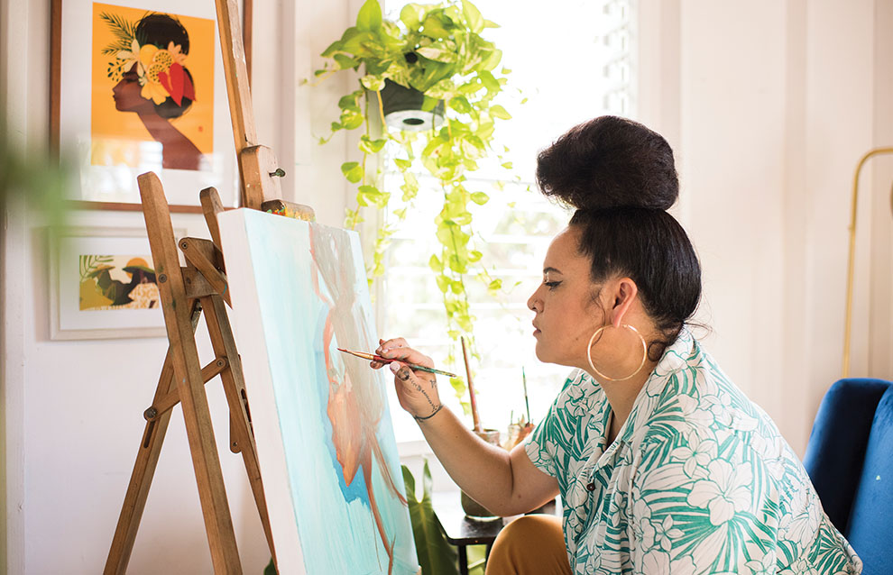 A woman is engaged in painting on a canvas at home
