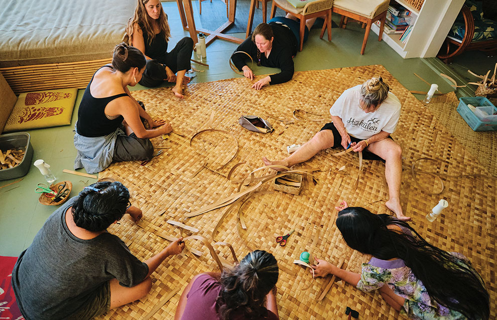 a group of people working on woven bamboo