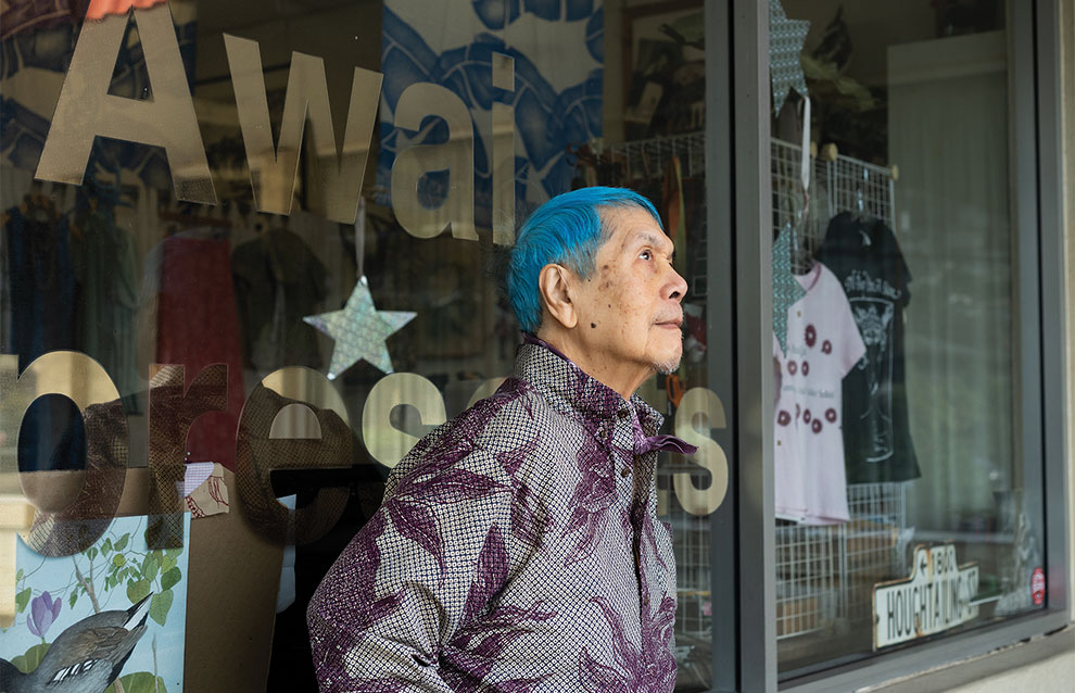 photo of a person with blue hari standing by a window