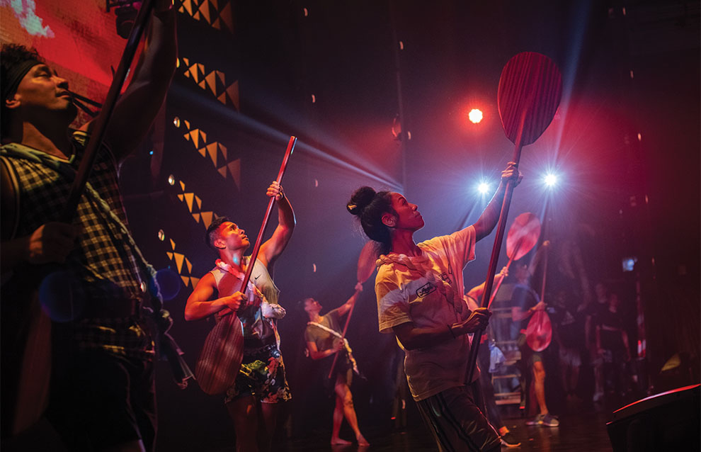 a group of people performing on stage with costumes