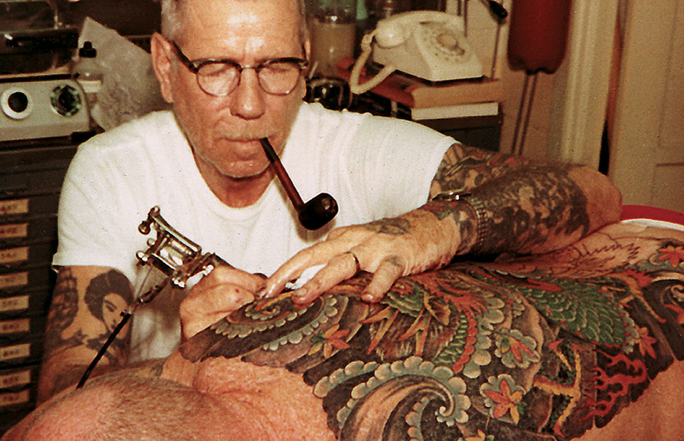 person tattooing another person on their back